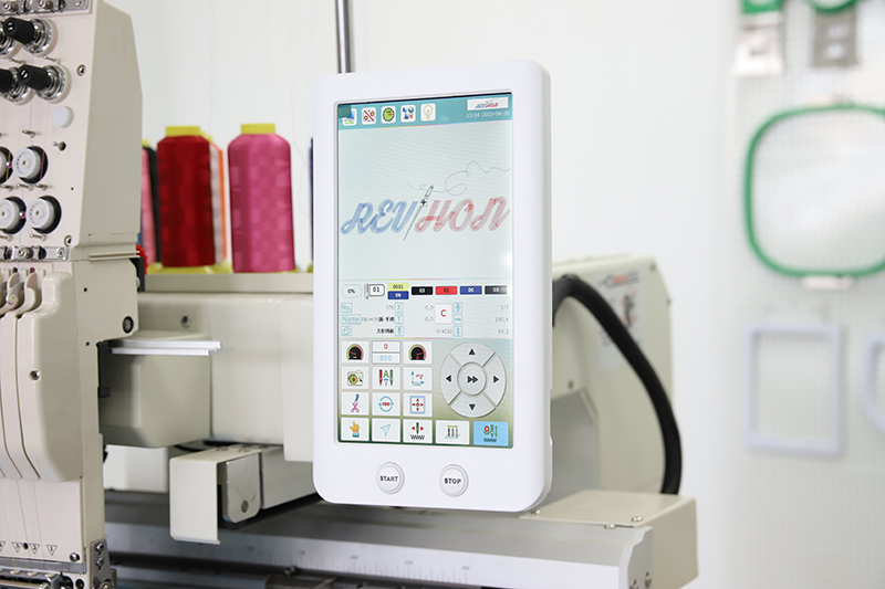 Embroidery machine control panel with colorful thread spools in the background